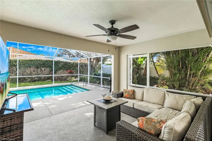 View of pool featuring a sunroom, a lanai, outdoor seating, and patio surround
