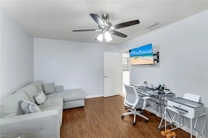 Home office featuring dark wood-style flooring and ceiling fan