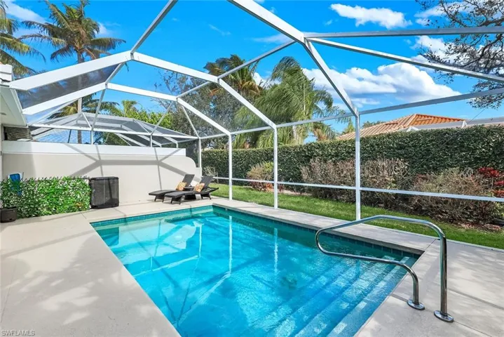 View of swimming pool with a sunroom, a lanai, a fenced backyard, and patio surround