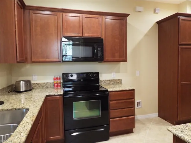 Kitchen has black stainless steel appliances and granite counters- $2500 credit for new refrigerator