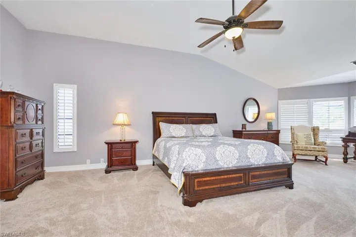 Owner's suite has plantation shutters, lighted ceiling fan, and a large walk-in closet with dressing room.