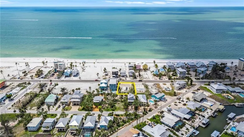 Drone / aerial view featuring a water view, a residential view, and a view of the beach  - Virtually Edited Image