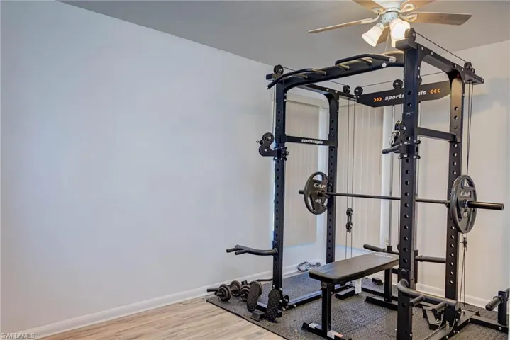 Workout room with baseboards, a ceiling fan, and wood finished floors
