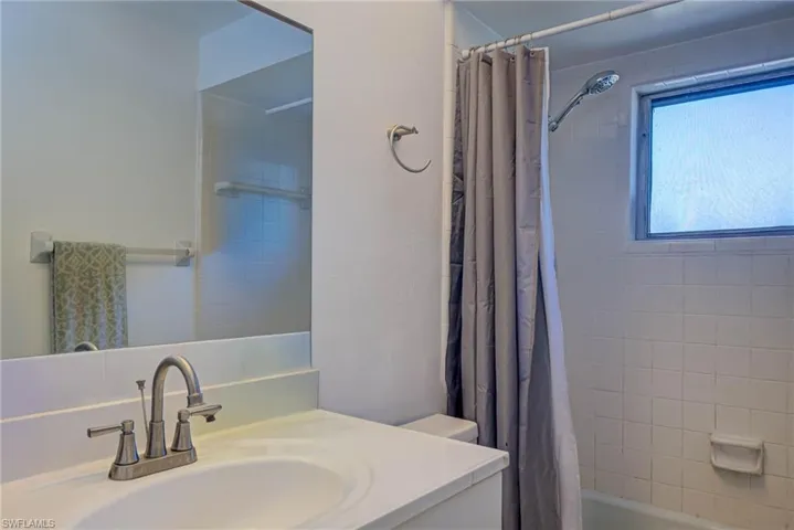 Bathroom with vanity and shower / bath combo with shower curtain