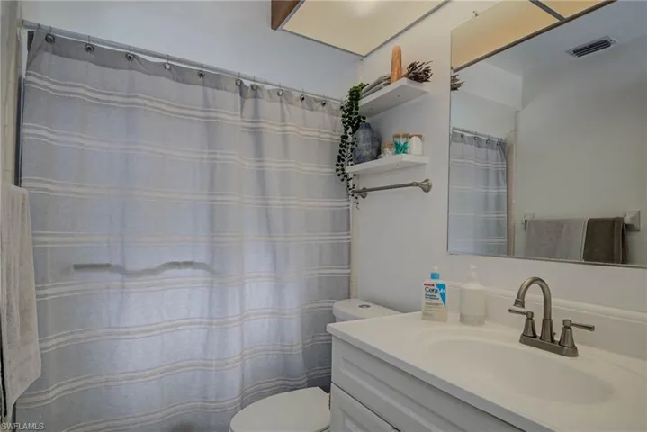 Bathroom featuring vanity, toilet, and visible vents