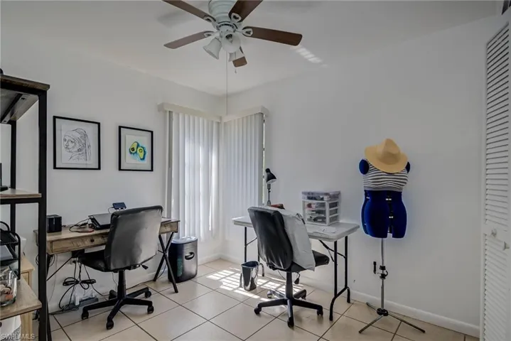 Office area featuring baseboards, a ceiling fan, and light tile patterned floors