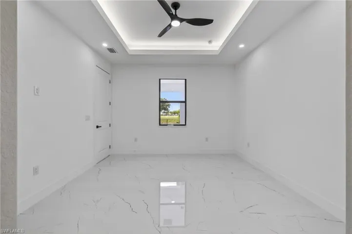 Bright interior space featuring white walls and large format tile flooring