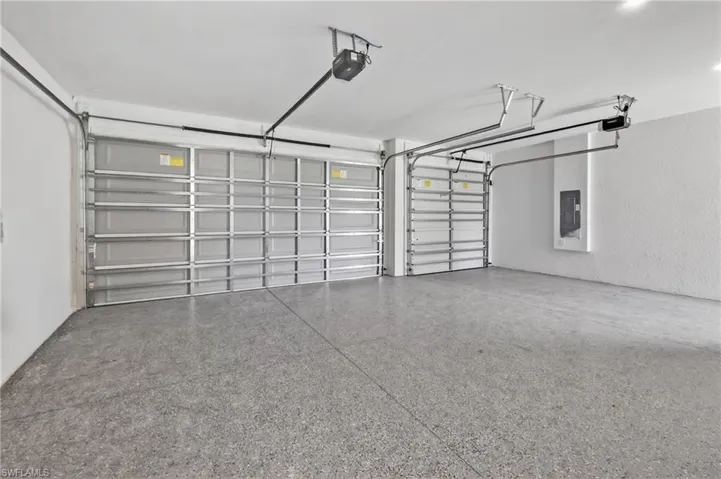 Garage featuring two overhead doors, automatic openers, and a speckled epoxy floor finish