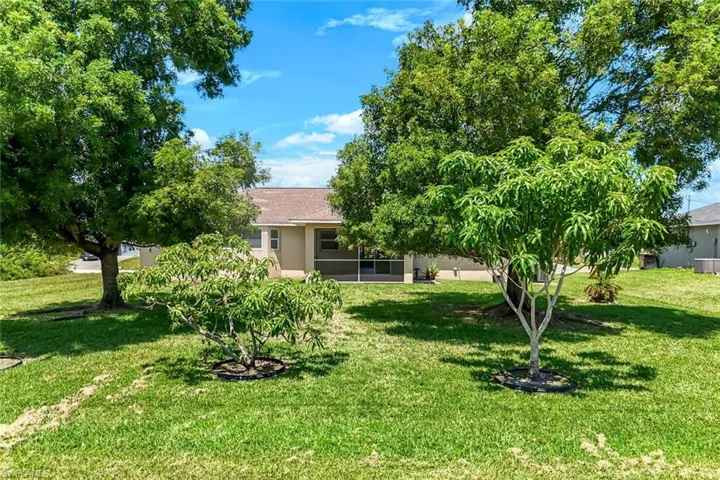 View of grassy yard with a sunroom