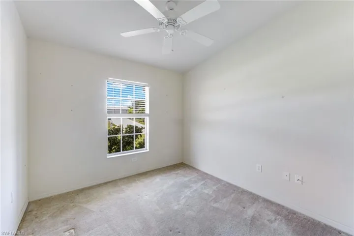 Unfurnished room featuring carpet floors and ceiling fan