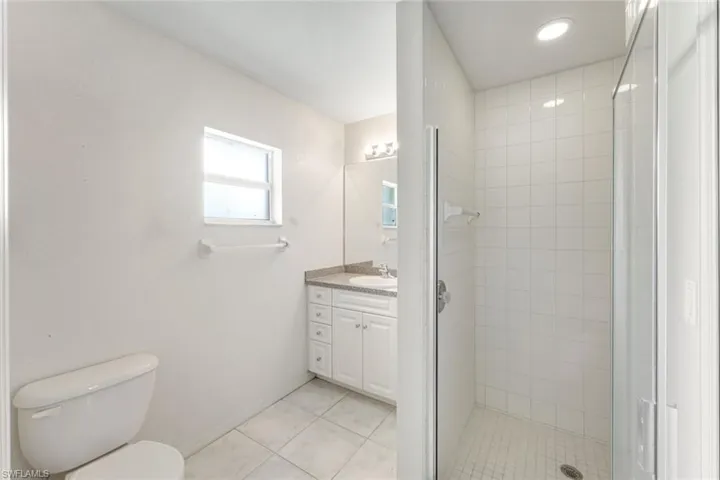 Full bath featuring vanity, tile patterned floors, a stall shower, and recessed lighting