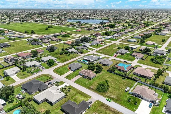 Aerial view of property and surrounding area featuring a large body of water and nearby suburban area