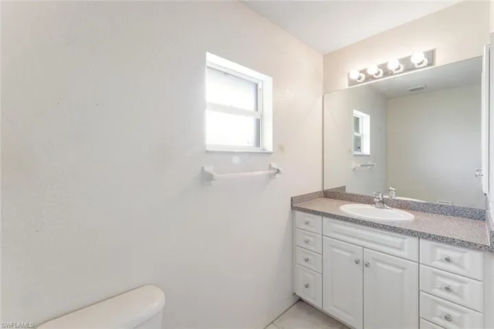 Bathroom featuring vanity and a textured wall