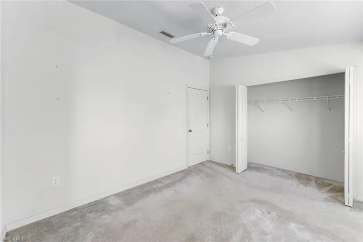 Unfurnished bedroom with carpet, a closet, and ceiling fan