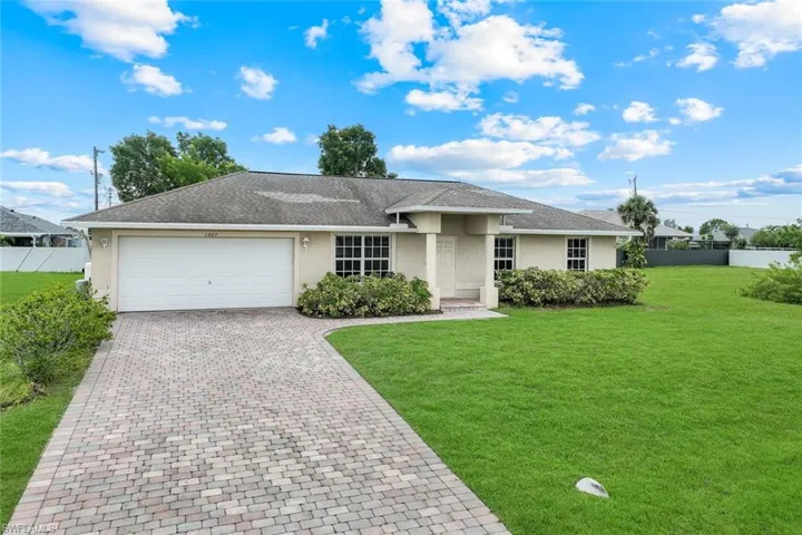 Single story home with stucco siding, decorative driveway, an attached garage, and a shingled roof