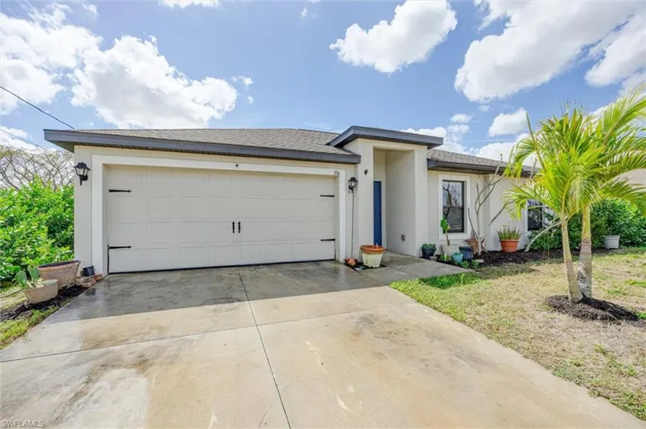 View of front of property with driveway, a garage, stucco siding, and roof with shingles