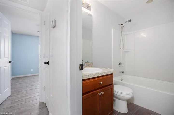 Bathroom with wood tiled floors, vanity, and shower / bathtub combination