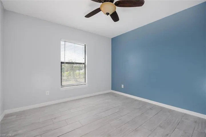 Unfurnished room featuring a ceiling fan and wood tiled floors