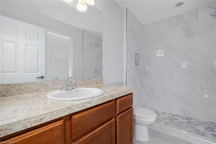 Bathroom with vanity and tiled shower