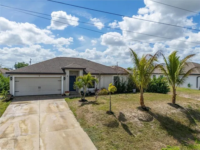 Ranch-style house with driveway, stucco siding, a shingled roof, an attached garage, and a front lawn