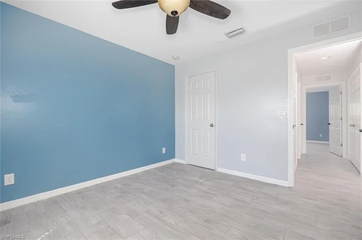 Unfurnished bedroom with ceiling fan, light wood-type flooring, and a closet