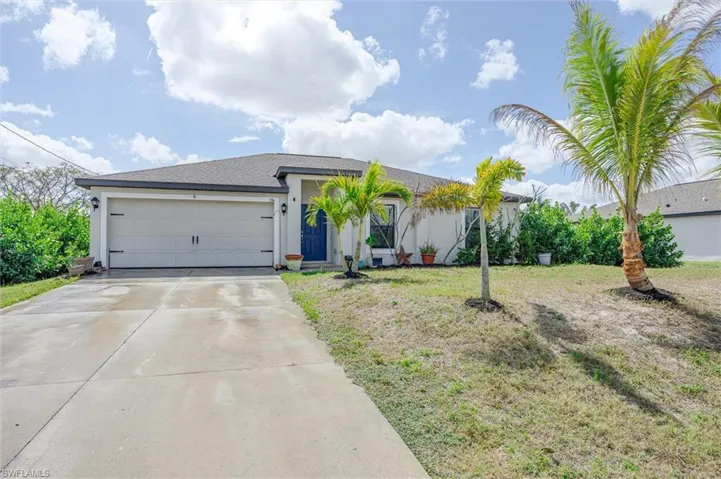 Ranch-style home featuring concrete driveway, a front lawn, an attached garage, stucco siding, and roof with shingles