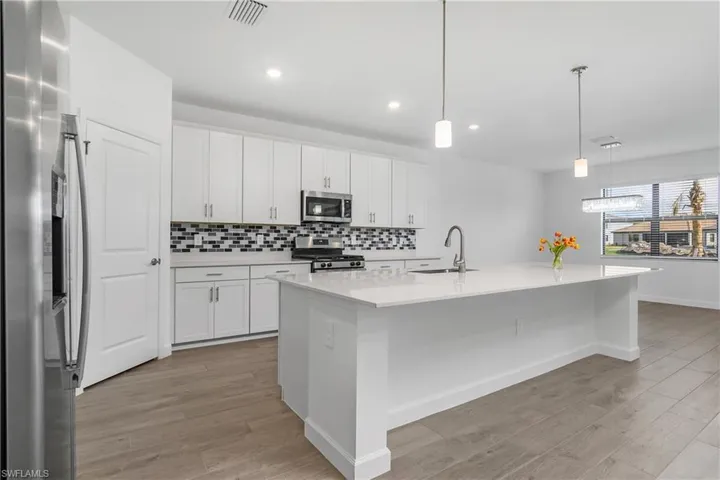 Spacious kitchen is a chef's dream featuring natural gas stove/cooktop, oversized island, walk-in pantry, and family dining space.