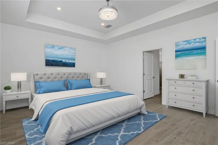 Primary bedroom is spacious and includes additional recessed lighting, chandelier/ceiling fan, and spa-like bath. (Furniture digitally added)