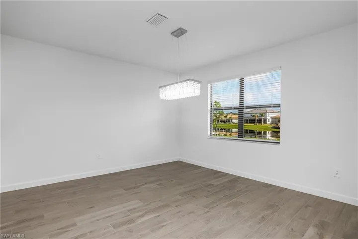 Family dining space is located just off the kitchen and features designer lighting and plenty of natural light.