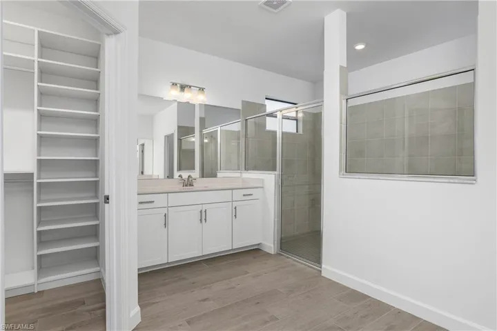 Primary bath features dual vanities, oversized walk-in shower, and his/hers closets with custom built-ins.