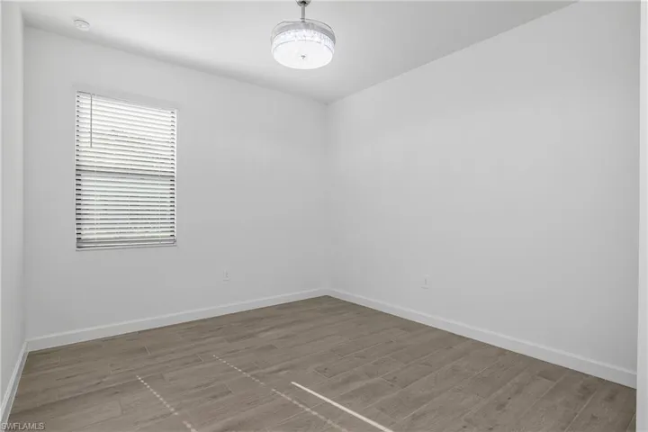 Spacious guest bedroom at the front of the home includes chandelier/ceiling fan and plenty of natural light.