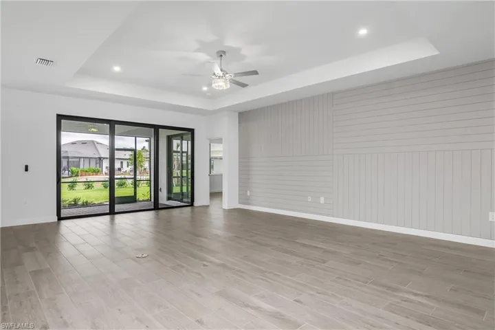 Spacious great room with feature wall, additional recessed lighting and lighted ceiling fan provide plenty of light.