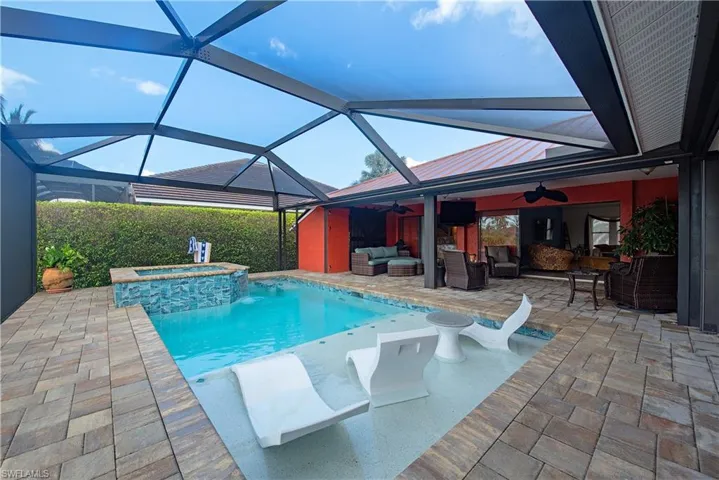 View of swimming pool with outdoor lounge area, ceiling fan, a patio, a pool with connected hot tub, and a lanai