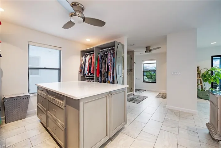 Walk in closet with a ceiling fan