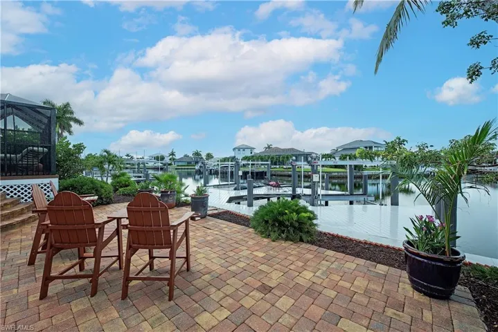 View of patio / terrace featuring boat lift, a dock, and a water view