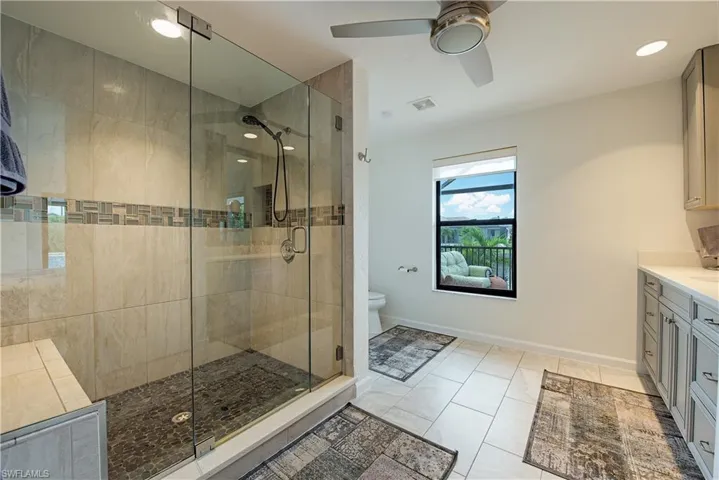 Bathroom featuring vanity, a shower stall, tile patterned floors, ceiling fan, and recessed lighting