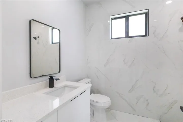 Bathroom with vanity and marble look tiles