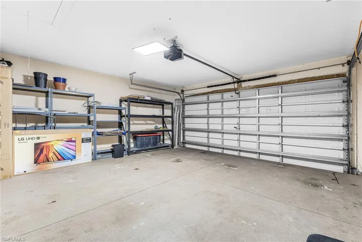 Attached garage with a concrete floor, overhead lighting, and an automatic garage door opener