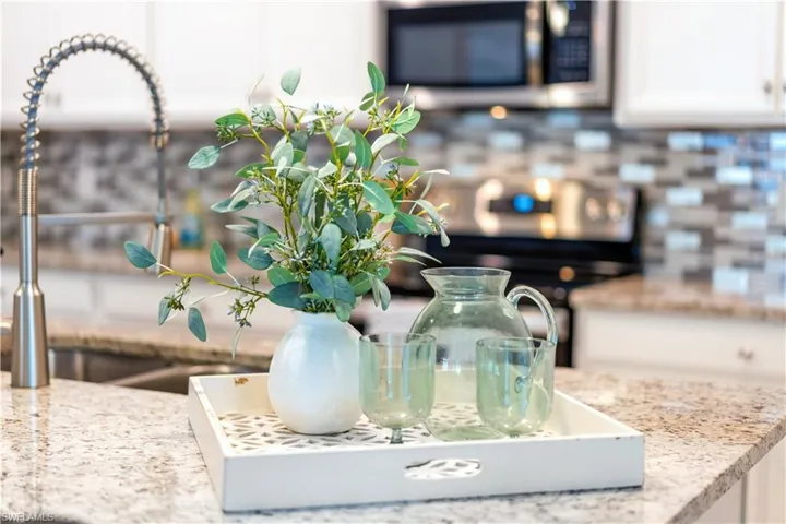 Details featuring stove, sink, and white cabinets