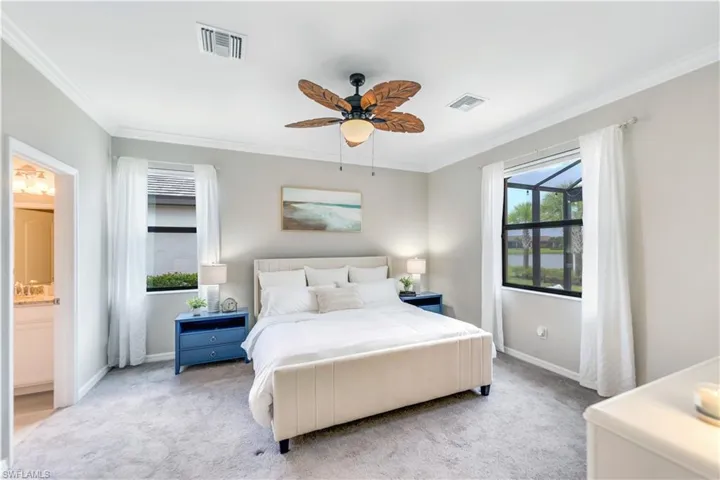 Bedroom featuring connected bathroom, ornamental molding, carpet floors, and ceiling fan