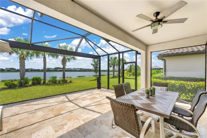 View of patio / terrace with a water view, ceiling fan, and a lanai