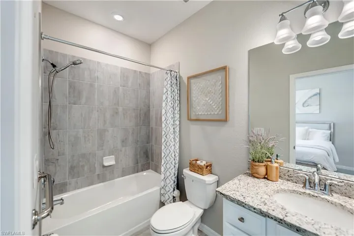 Full bathroom featuring toilet, shower / tub combo with curtain, and vanity