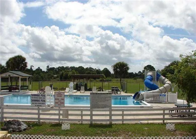 Community pool featuring a water slide, a gazebo, and a patio area