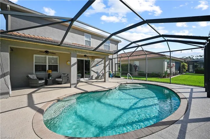 View of swimming pool featuring a patio, an outdoor hangout area, ceiling fan, and glass enclosure