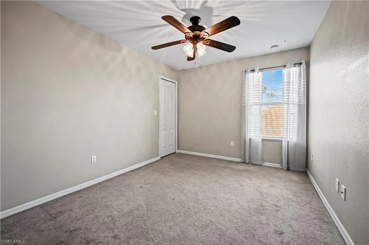 Empty room with carpet and ceiling fan