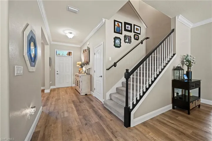 Entrance foyer featuring wood-type flooring and crown molding