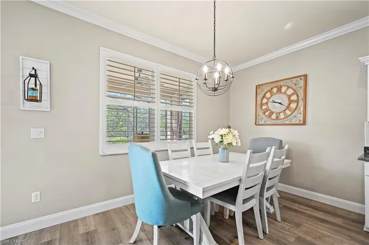 Dining space featuring an inviting chandelier, dark hardwood / wood-style floors, and ornamental molding