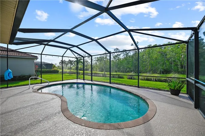 View of swimming pool featuring a patio area, a lanai, and a lawn