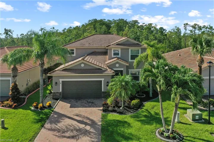Mediterranean / spanish-style home with a garage and a front lawn