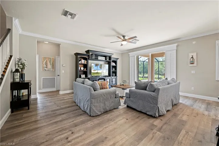 Living room featuring crown molding, hardwood / wood-style floors, and ceiling fan